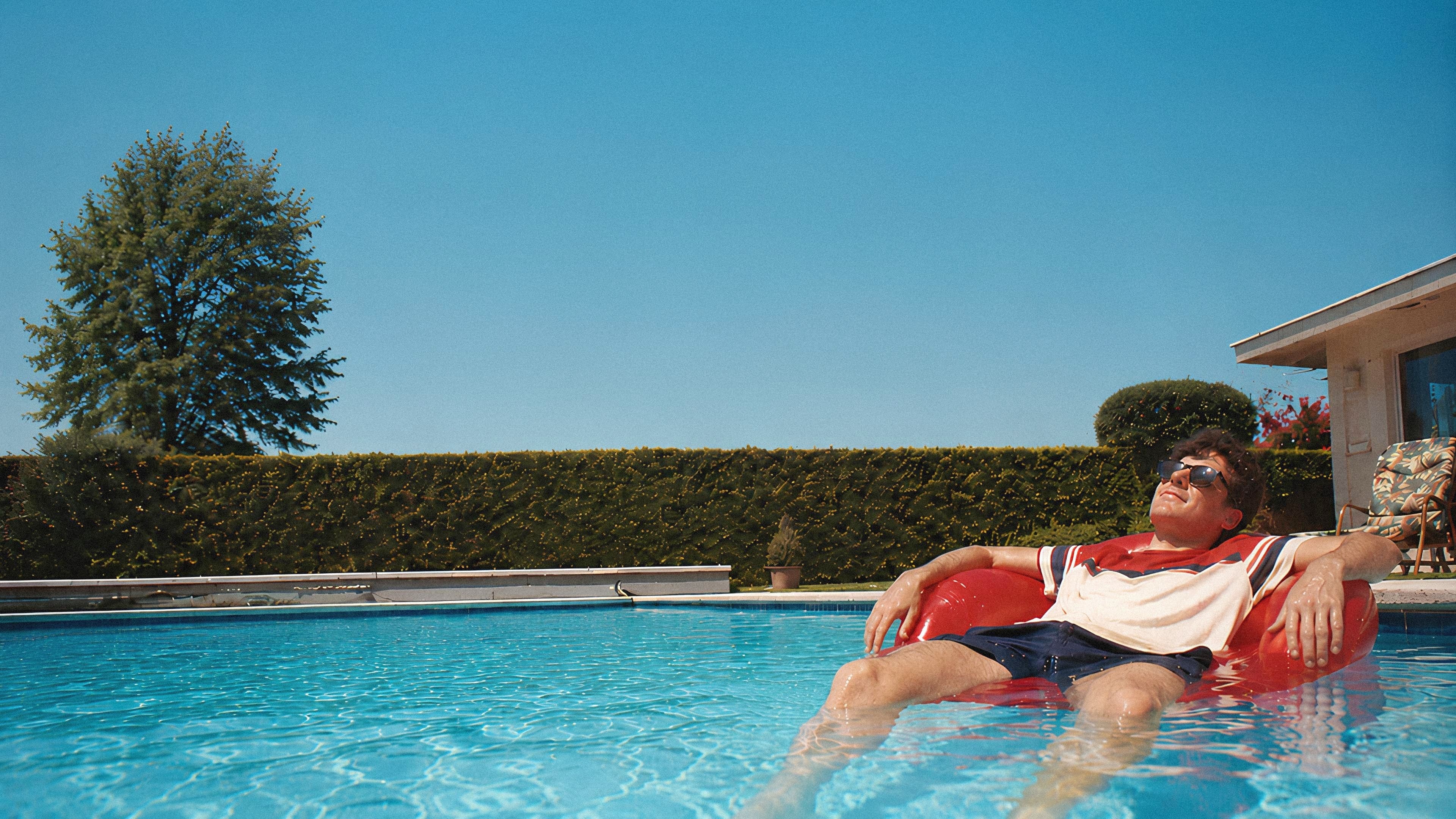Man relaxing in a swimming pool after booking trampoline assembly in Auckland